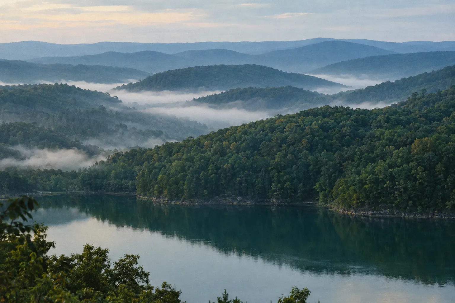 Layered Ozark ridgelines with morning fog above a calm lake in Northwest Arkansas